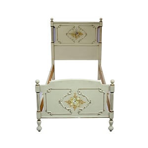 Puede incluir: Armazón de cama antigua color crema con detalles florales. El cabecero y el piecero presentan diseños florales pintados dentro de paneles decorativos con bordes dorados. El armazón de la cama tiene postes redondeados y pies decorativos.