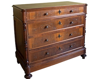 Puede incluir: Cómoda de madera oscura con cuatro cajones y un cajón superior. La madera es de color marrón oscuro con tallas florales decorativas y herrajes de metal oscuro. La cómoda tiene cuatro patas.