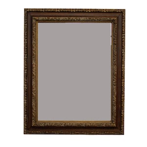 May include: Rectangular mirror with a dark brown, ornate frame. The frame features detailed carvings and a gold-colored trim. The mirror's surface is a muted gray color, reflecting a neutral tone. The overall design is classic and decorative.