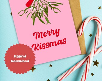 May include: A pink greeting card with the words "Merry Kissmas" and a mistletoe illustration with a red bow. The card is on a light blue surface with gold star confetti and a brown envelope. Two candy canes are also present.