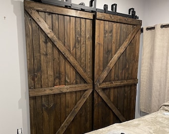 Könnte beinhalten: Zwei braune Holzschiebetüren mit einem schwarzen Metallschienensystem. Die Türen haben ein diagonales X-förmiges Design und sind geschlossen.