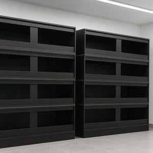 Op de afbeelding: Twee zwarte opslageenheden met meerdere planken. Elke eenheid heeft vier planken en een bovenste gedeelte. De eenheden zijn gemaakt van donker hout of een vergelijkbaar materiaal. De eenheden staan in een kamer met witte muren en een betegelde vloer.