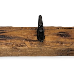 Solid wood nautical theme style look wall mounted coat or towel rack for the bathroom or entryway. This coastal themed towel hooh has rust proof black cast iron boat dock cleats or deck hooks. the wood is distressed and aged with the look of driftwood or reclaimed wood.