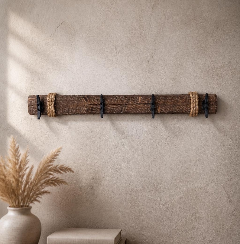 Solid wood nautical theme style look wall mounted coat or towel rack for the bathroom or entryway. This coastal themed towel hooh has rust proof black cast iron boat dock cleats or deck hooks. the wood is distressed and aged with the look of driftwood or reclaimed wood.