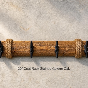 Solid wood nautical theme style look wall mounted coat or towel rack for the bathroom or entryway. This coastal themed towel hooh has rust proof black cast iron boat dock cleats or deck hooks. the wood is distressed and aged with the look of driftwood or reclaimed wood.