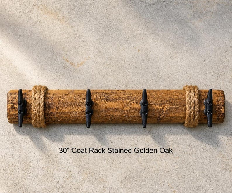 Solid wood nautical theme style look wall mounted coat or towel rack for the bathroom or entryway. This coastal themed towel hooh has rust proof black cast iron boat dock cleats or deck hooks. the wood is distressed and aged with the look of driftwood or reclaimed wood.