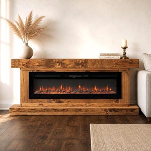 May include: A rectangular electric fireplace console constructed from dark stained wood with a prominent grain pattern. The unit features a wide, black glass-fronted firebox displaying a glowing orange flame effect and artificial logs.