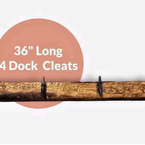 Solid wood nautical theme style look wall mounted coat or towel rack for the bathroom or entryway. This coastal themed towel hooh has rust proof black cast iron boat dock cleats or deck hooks. the wood is distressed and aged with the look of driftwood or reclaimed wood.