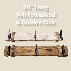 Solid wood nautical theme style look wall mounted coat or towel rack for the bathroom or entryway. This coastal themed towel hooh has rust proof black cast iron boat dock cleats or deck hooks. the wood is distressed and aged with the look of driftwood or reclaimed wood.