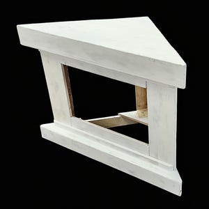 Pu&ograve; includere: Un mobile TV d'angolo bianco con uno scaffale e uno spazio aperto per un televisore. Il mobile &egrave; in legno e ha uno stile rustico e da fattoria.