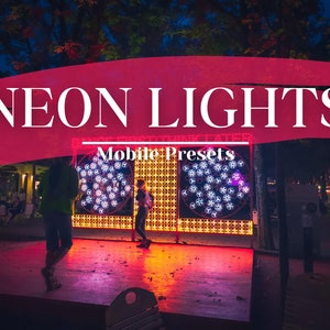 Puede incluir: Luces de neón iluminan un escenario con un letrero rosa y blanco que dice "NEON LIGHTS Mobile Presets".