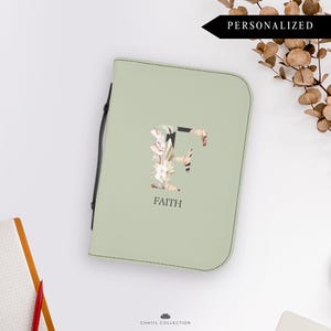 May include: A light green personalized bible cover with a floral letter "F" and the word "FAITH" printed in black.