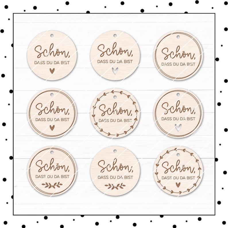 May include: Nine round wooden tags with the text "Schon, Dass du da bist" in brown lettering. Some tags have a heart design, while others have a wreath design.