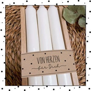 May include: Three white candles in a wooden box with a brown paper tag that says "Von Herzen f&uuml;r Dich".