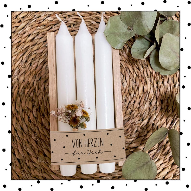 May include: Three white candles in a wooden holder with a brown paper tag that says "Von Herzen f&uuml;r Dich".