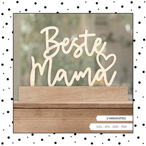 Könnte beinhalten: Holzschilder mit dem Text "Beste Mama" in kursivschrift mit einem Herzsymbol. Das Schild steht auf einem Holzsockel.