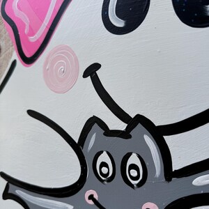 May include: A white ghost with a pink bow and black eyes is holding a gray bat with black eyes and a pink mouth. The bat has white teeth and is smiling.