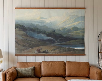 May include: A brown leather sectional sofa with a white throw blanket on the chaise lounge. The sofa is in front of a white wall with a framed landscape painting above it.