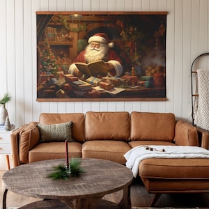 K&ouml;nnte beinhalten: Ein braunes Ledersofa in L-Form mit einer wei&szlig;en Wolldecke auf der Chaiselongue. Ein runder Holz-Couchtisch steht vor dem Sofa. Ein gerahmtes Bild von Santa Claus, der in seiner Werkstatt ein Buch liest, h&auml;ngt an der Wand &uuml;ber dem Sofa.