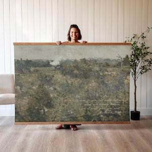 May include: A large landscape painting with a wooden frame. The artwork features a muted color palette of greens, browns, and grays, depicting a field or meadow. The text "Come to me, all who labor..." is visible in the lower right corner.