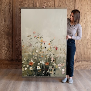 May include: A large abstract painting depicting a field of flowers in shades of green, pink, orange, and white. The flowers are painted in a loose, impressionistic style, and the background is a soft, muted grey.
