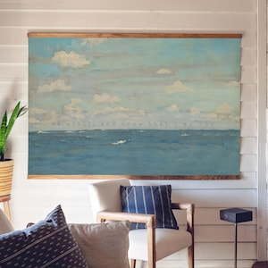 Pu&ograve; includere: Un'opera d'arte murale su tela incorniciata raffigurante un paesaggio marino con un oceano blu e un cielo nuvoloso. L'opera d'arte &egrave; incorniciata con un bordo in legno e include il testo "Be still, and know that I am God."