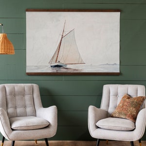 May include: A framed watercolor painting of a sailboat with white sails on a calm body of water. The painting is in a wooden frame and has a white mat.