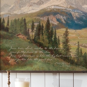 May include: An oil painting depicts a mountain landscape with a small cabin and evergreen trees. The artwork features a quote from Psalm 36:5-6 in white script. The color palette includes greens, browns, and blues.