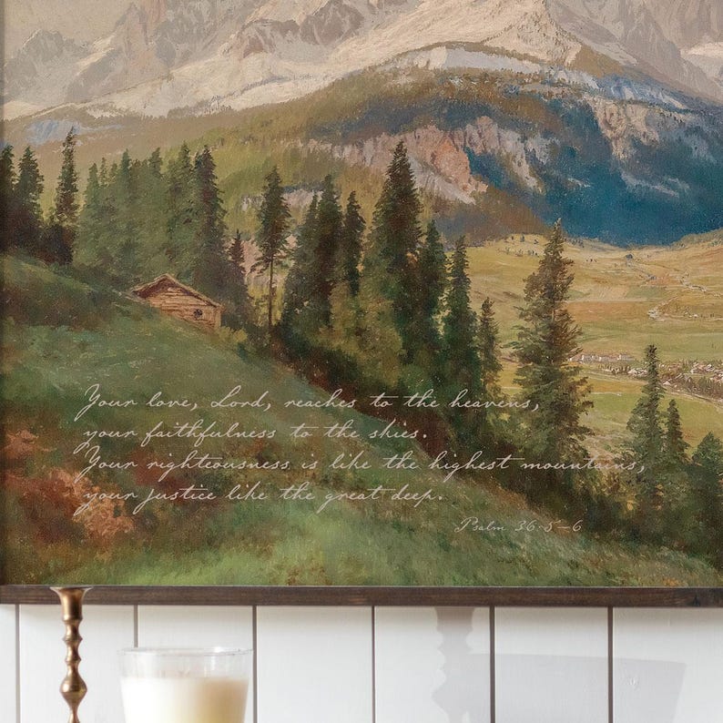 May include: An oil painting depicts a mountain landscape with a small cabin and evergreen trees. The artwork features a quote from Psalm 36:5-6 in white script. The color palette includes greens, browns, and blues.