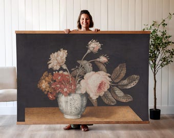 May include: A still life painting of a bouquet of pink and white roses, carnations, and other flowers in a white porcelain vase with a floral design. The flowers are arranged on a wooden table against a dark background.