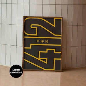 May include: A framed art print featuring the number "42" in a yellow, geometric design against a black background. The letters "PGH" are centered above the number. The frame is a dark wood color. The words "Digital Download" are in a black circle in the lower left corner.
