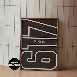 May include: A framed black and white art print featuring the number 56 with the letters BOS in the center. The print has a minimalist design with bold, white lines on a black background. The frame is a dark brown color. A digital download icon is in the lower left corner.