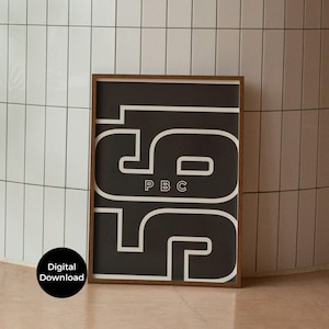 Puede incluir: Una impresión artística en blanco y negro enmarcada con los números "56" en una fuente audaz y estilizada. Las letras "PBC" están centradas en el diseño. La impresión está en un marco de madera marrón. Un círculo negro con las palabras "Descarga digital" está en la esquina inferior izquierda.