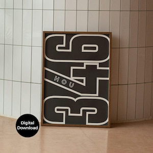 May include: A framed black and white art print featuring the numbers "346" in a bold, outlined font. The word "HOU" is printed diagonally across the numbers. The frame is a dark brown color. A digital download is available.