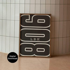 May include: A framed art print with the numbers "908" in white on a black background, with "LBK" below. The artwork has a white outline and is set in a brown frame. The words "Digital Download" are in a black circle in the lower left corner.