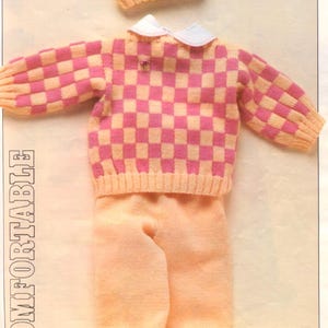 May include: A knitted baby outfit in peach and pink. The set includes a hat, a sweater with a pink and peach checkerboard pattern, a pair of pants, and pink shoes. The sweater has a white collar. The text in the image says "Explained from 6-18 months."