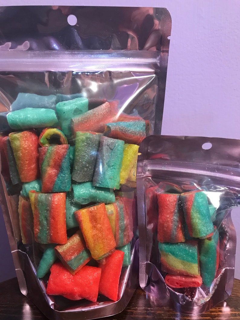 May include: Two clear plastic bags filled with colorful rainbow swirl candy. The candy is in the shape of small rolls. The larger bag is filled with more candy than the smaller bag.