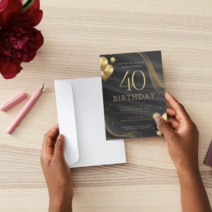 Puede incluir: Invitaci&oacute;n de cumplea&ntilde;os n&uacute;mero 40 en negro y dorado, sostenida por manos. La invitaci&oacute;n presenta texto y gr&aacute;ficos dorados. Tambi&eacute;n se ven un sobre blanco, un bol&iacute;grafo rosa y una flor burdeos.