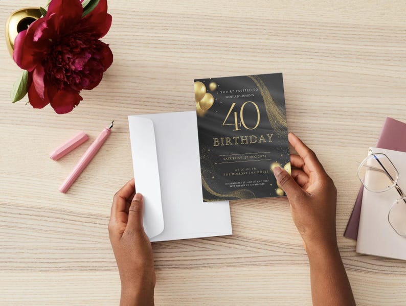 Puede incluir: Invitaci&oacute;n de cumplea&ntilde;os n&uacute;mero 40 en negro y dorado, sostenida por manos. La invitaci&oacute;n presenta texto y gr&aacute;ficos dorados. Tambi&eacute;n se ven un sobre blanco, un bol&iacute;grafo rosa y una flor burdeos.