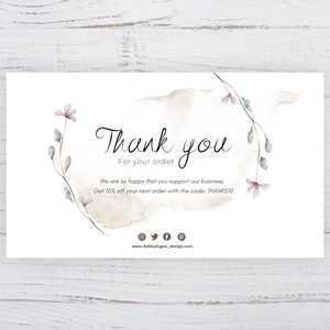 Op de afbeelding: Een witte bedankkaart met een aquarel bloemenontwerp en de tekst "Bedankt" en "Voor uw bestelling". De kaart bevat ook de tekst "We zijn zo blij dat u ons bedrijf steunt. Krijg 10% korting op uw volgende bestelling met de code: THANKSIO" en een websiteadres.
