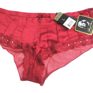 May include: Red satin and lace underwear with a rhinestone trim and a small tag that says "S.L."