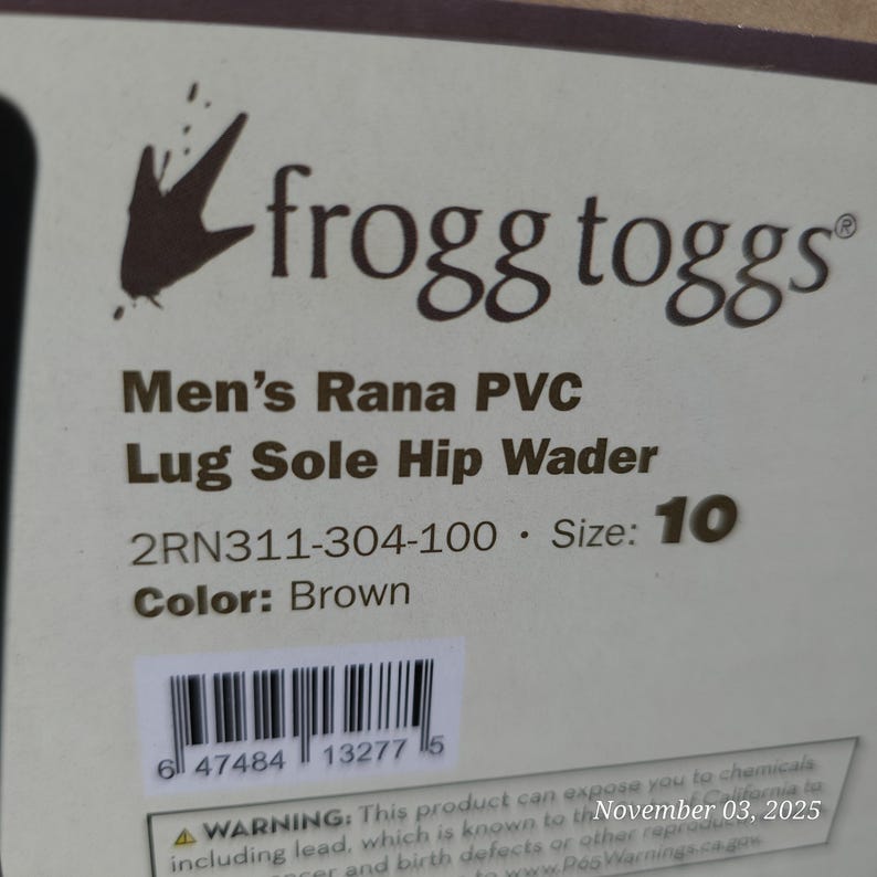 May include: A product label for Frogg Toggs Men's Rana PVC Lug Sole Hip Waders. The label is white with black text, including the brand logo, product details, size 10, and brown color. A barcode is also visible.