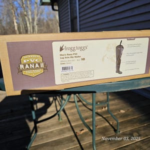 May include: A brown cardboard box featuring a pair of brown hip waders. The box has the text "frogg toggs" and "Men's Rana PVC Lug Sole Hip Wader." The size is 10. The box also has the text "DURABLE PVC RANAII CHESTWADER & HIP BOOT."