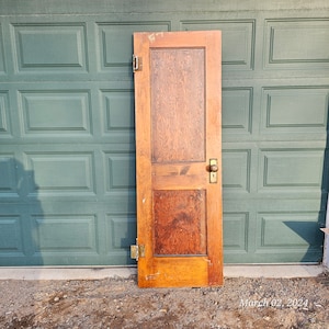 May include: A solid wood door with a raised panel design. The door is stained a dark brown color and has a brass door knob and hinges.