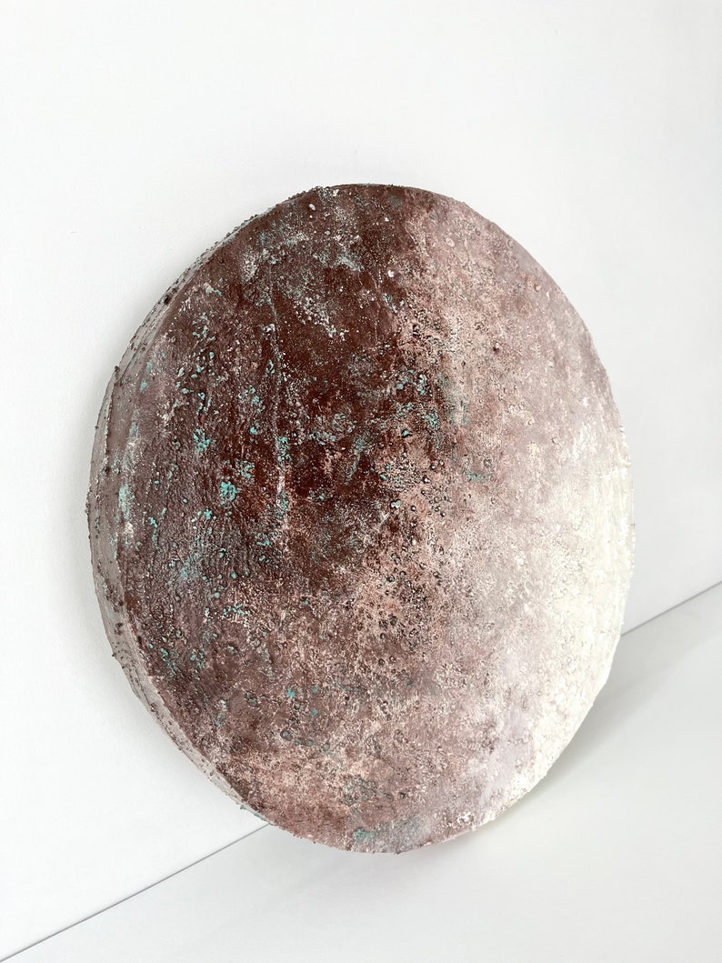 May include: A round, brown and white ceramic plate with a textured surface. The plate has a gradient of color, with the brown color fading to white.
