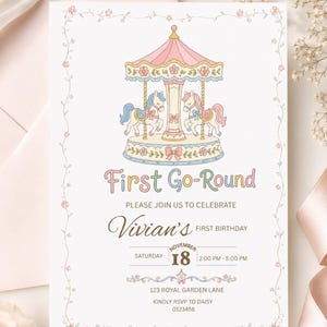 May include: A white rectangular invitation card featuring a pastel carousel illustration with two horses, surrounded by a delicate floral border. The text reads First Go-Round, Vivian's First Birthday, Saturday November 18, 2:00 PM - 5:00 PM, 123 Royal Garden Lane, and Kindly RSVP to Daisy 0123456.