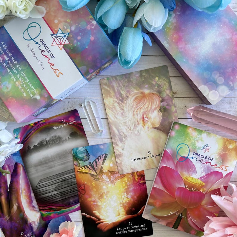 May include: A set of oracle cards with a pink, purple, and blue color scheme. The cards feature illustrations of a misty forest, a butterfly, a lotus flower, and a child with a halo. The cards are titled "Oracle of Oneness" and feature the text "Let innocence fill your" and "Let go of control and welcome transformation".
