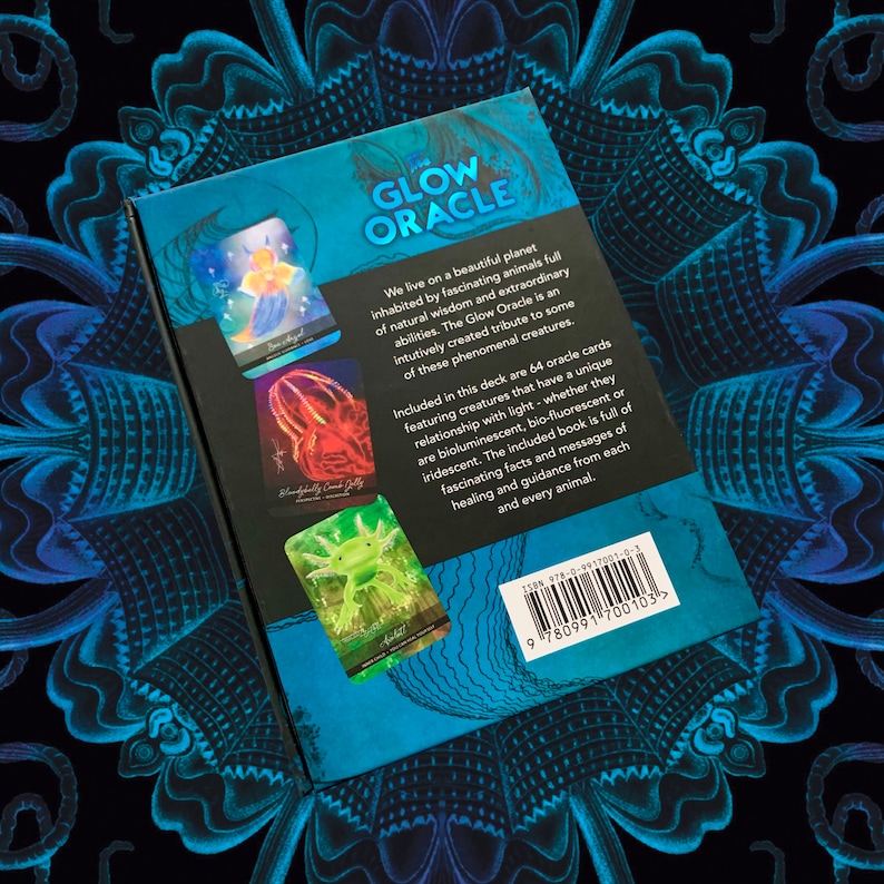 Peut inclure: Le dos d'une bo&icirc;te pour un jeu de cartes Oracle Glow. La bo&icirc;te est bleue et pr&eacute;sente des images de cr&eacute;atures brillantes. Le texte sur la bo&icirc;te indique "Glow Oracle" et "Nous vivons sur une belle plan&egrave;te habit&eacute;e par des animaux fascinants, riches en sagesse naturelle et en capacit&eacute;s extraordinaires. Le Glow Oracle est un hommage cr&eacute;&eacute; de mani&egrave;re intuitive &agrave; certaines de ces cr&eacute;atures ph&eacute;nom&eacute;nales."