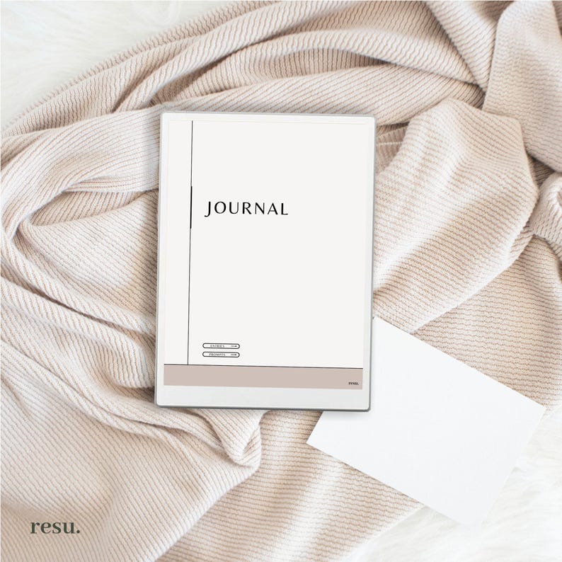 May include: A white journal with a black vertical line and the word "JOURNAL" printed in black at the top. The journal has a brown section at the bottom with two lines of text.