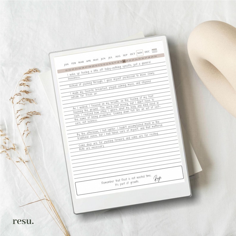 May include: A white digital planner with a black screen displaying a handwritten daily journal entry. The entry includes a calendar with dates for each month of the year, and a handwritten message about taking time for rest and self-care. The message reads "Remember that Rest is not wasted time. It's part of growth."